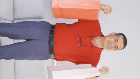 Vertical-video-of-Old-man-showing-shopping-bags-to-camera.